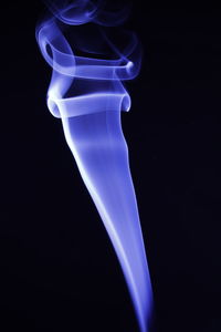 Close-up of illuminated lighting equipment against black background
