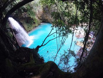 Scenic view of waterfall in forest against sky