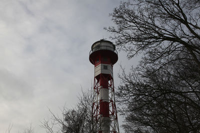 Low angle view of lighthouse by building against sky