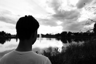 Rear view of a boy overlooking calm lake