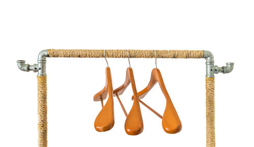 Close-up of clothes hanging on rope against white background