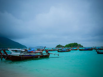 Boats moored in sea against sky