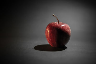 Close-up of apple on table against gray background