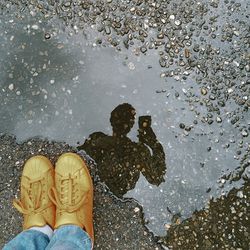 Low section of person standing in puddle