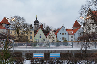 Houses and buildings against sky during winter