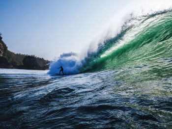 View of person surfing in waves in sea