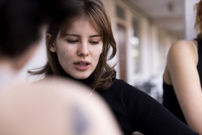 Young woman looking down with friend in balcony