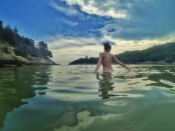 Rear view of man standing in sea