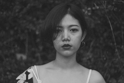 Portrait of young woman against plants