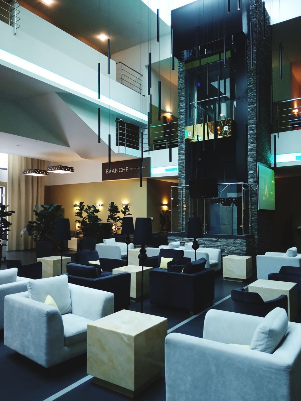 EMPTY CHAIRS AND TABLES IN ILLUMINATED RESTAURANT