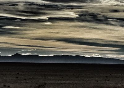 Scenic view of mountains against cloudy sky