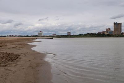 Scenic view of beach against sky in city