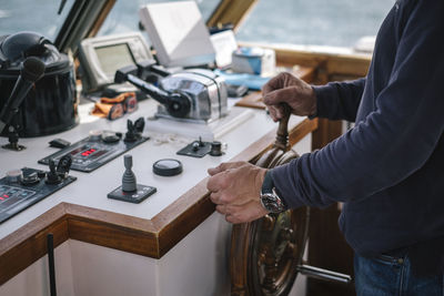 Midsection of boat captain in ship