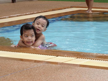 Portrait of siblings in swimming pool