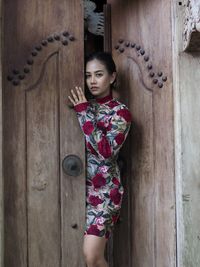 Portrait of cute girl standing against wall