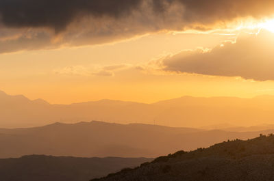 Scenic view of silhouette mountains against sky during sunset