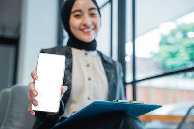 Portrait of young woman using mobile phone