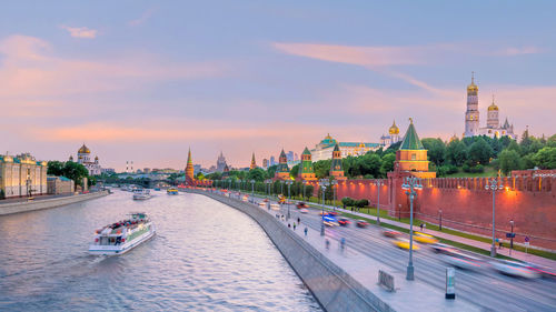 View of buildings at waterfront against cloudy sky