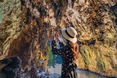 Rear view of woman standing on rock