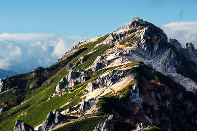 Mountain peak under sun lights against rocks