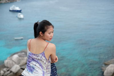 Side view of young woman looking at sea
