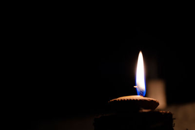 Close-up of burning candle in darkroom