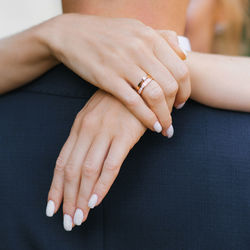 The bride hugs the groom by the neck. close-up of her hands with an engagement ring