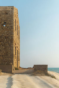 Built structure on beach against clear sky