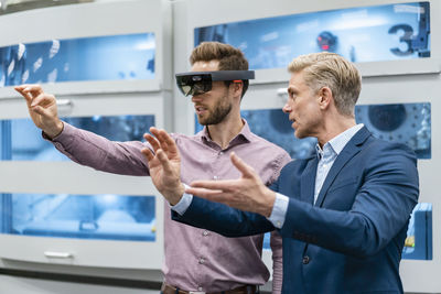 Two businessmen with ar glasses in a modern factory