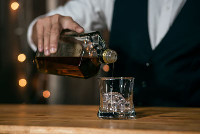 Man pouring wine in glass on table