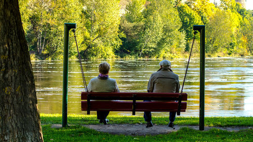 Rear view of man sitting on bench in park