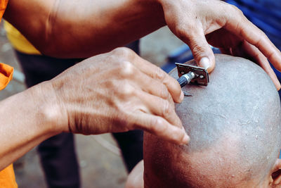 Close-up of man shaving head of boy