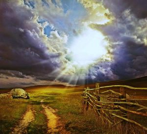 Scenic view of grassy field against cloudy sky