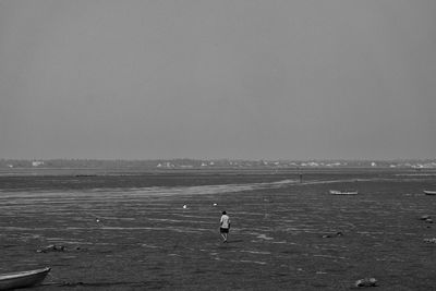 Man on beach against clear sky