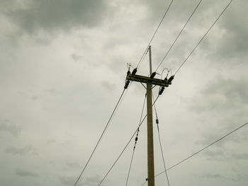 Low angle view of electricity pylon against sky