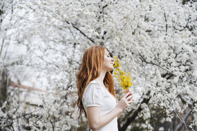 Low section of woman standing on cherry blossom