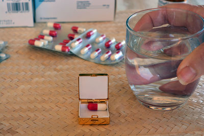 Cropped hand having pills on table