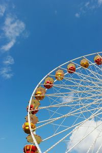 Low angle view of ferris wheel against blue sky