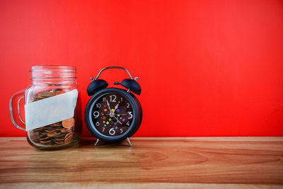 Close-up of clock on table against wall