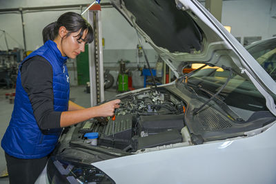 Side view of man repairing car