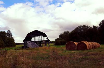 Hay bales on field against sky