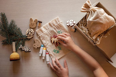 Girl doing craft wrapping for festive gifts with wooden stamp printing technique