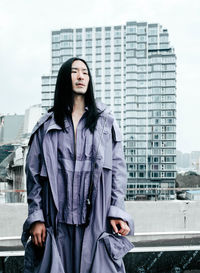 Young woman standing against building in city