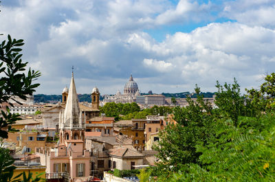 Buildings in city against cloudy sky