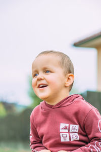 Portrait of cute boy standing against clear sky