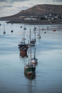 Sailboats moored in sea against sky