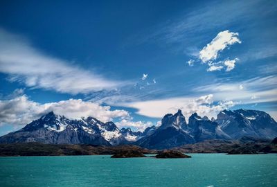 Scenic view of sea and snowcapped mountains against sky