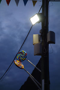 Low angle view of illuminated street light against sky