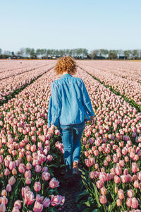 Rear view of woman walking on field