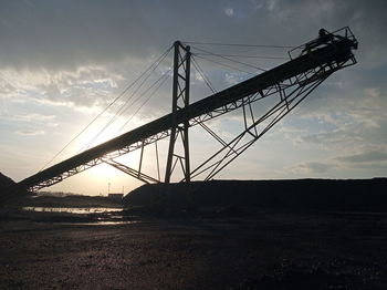 Low angle view of silhouette bridge against sky during sunset